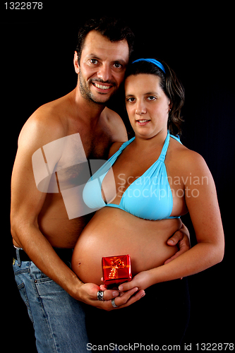 Image of beautiful and happy & young pregnant couple holding present