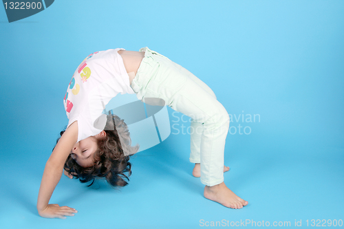 Image of beautiful girl gymnast doing the bridge, studio photo