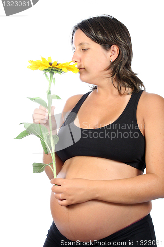 Image of pregnant woman with beautiful belly and sunflower