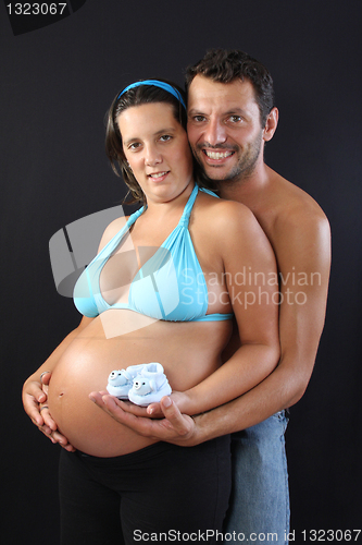 Image of beautiful and happy & young pregnant couple with baby socks