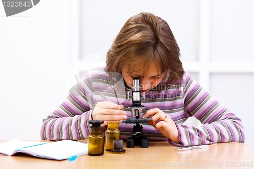 Image of Schoolgirl looking into microscope