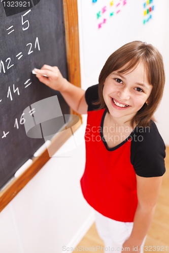 Image of Schoolgirl looking up in front of chalkboard