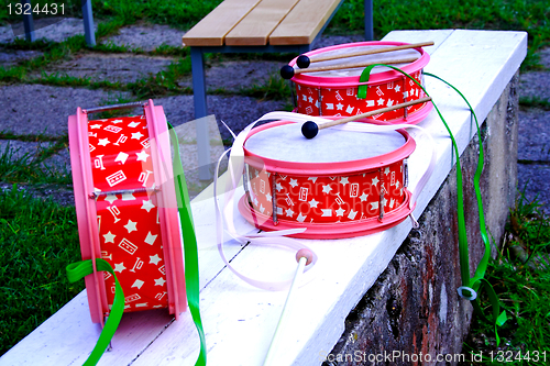 Image of Pink decorated drums laying on white bench