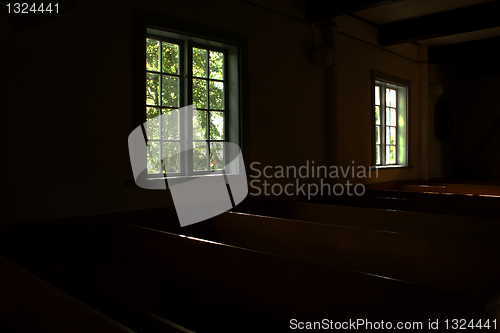 Image of Dark rooms of church lighted by windows