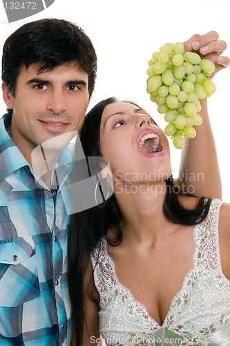 Image of Couple playfully eating grapes