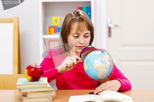 Image of Schoolgirl searching with magnifier 