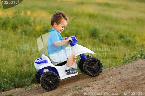 Image of Little boy driving off road toy quad