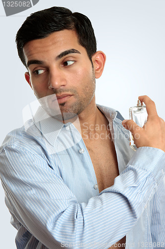 Image of Man spraying aftershave cologne perfume