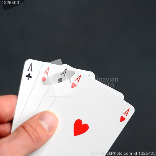 Image of hand holding four aces