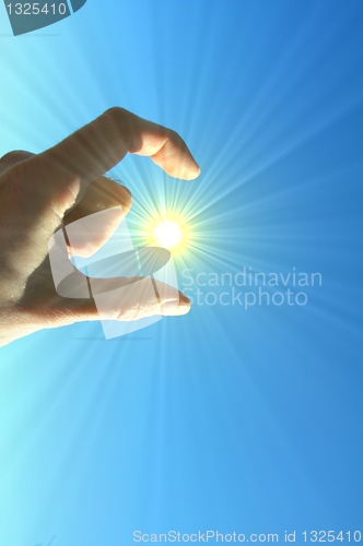 Image of hand fingers sky and sun