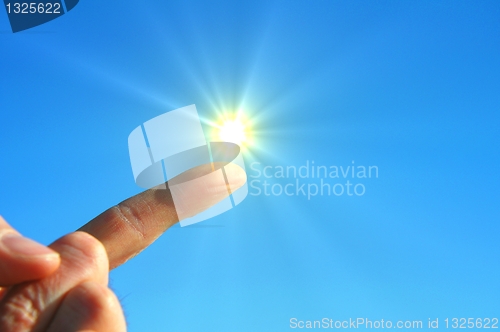 Image of hand sun and blue sky