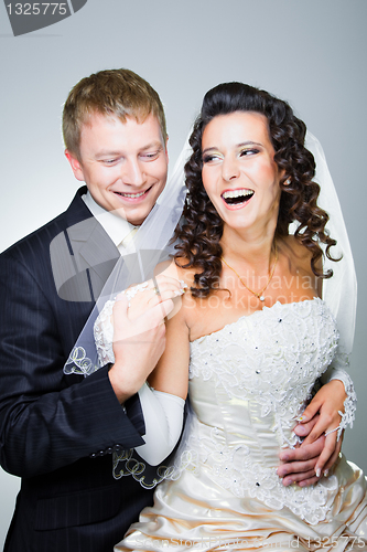 Image of Laughing groom and bride on grey
