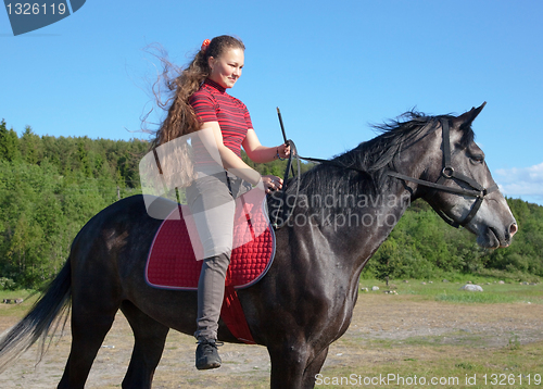 Image of A girl with long hair on a horse