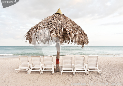 Image of Sandy beach, umbrella and chairs
