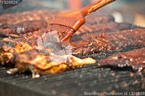 Image of Basting tasty ribs on the barbeque.