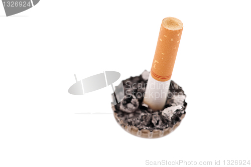 Image of cigarette butt in a bottle cap on white background