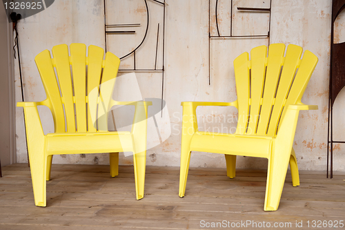 Image of Two yellow chairs on a porch