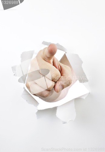 Image of Finger pointing through hole in paper