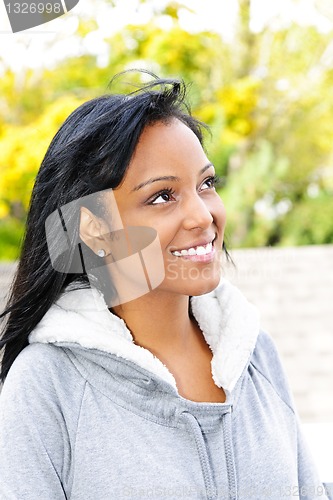 Image of Portrait of smiling young woman outdoors