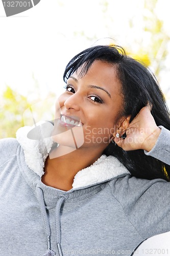 Image of Portrait of smiling young woman outdoors