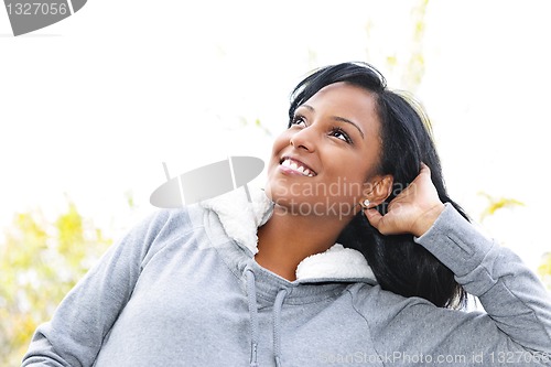 Image of Smiling young woman outdoors looking up