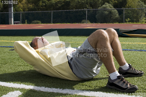 Image of middle age senior man exercising sit ups ab exercise on sports f