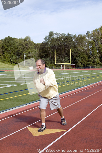 Image of middle age senior man exercising running on sports field and run