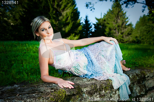 Image of attractive woman lying on stones