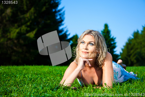 Image of attractive woman lying on green fresh