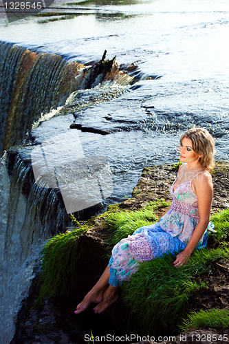 Image of beautiful girl on brink of river waterfalls