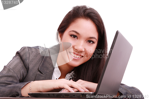 Image of portrait of a cute smiling businesswoman working on a laptop 