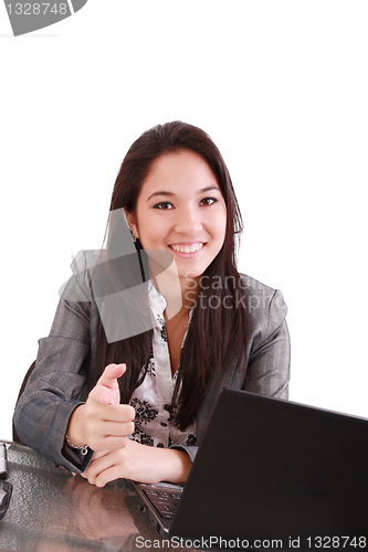 Image of business woman sitting on chair at desk in office and pointing t