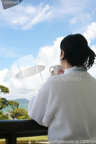 Image of Professional businesswoman with a bath dress holding coffee cup 