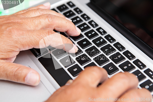 Image of Hands of old man on computer