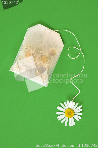 Image of Bag of chamomile tea over green background - concept