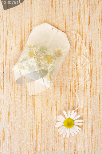 Image of Bag of chamomile tea over wooden background - concept