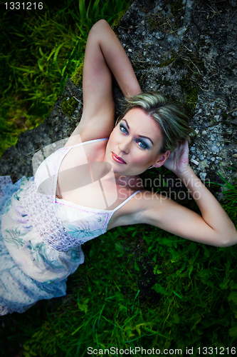 Image of attractive woman  lying on stones