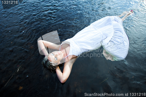 Image of beautiful woman floating in blue river