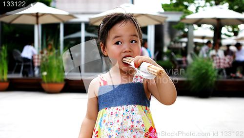 Image of Young Asian girl having a snack