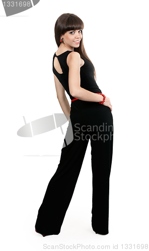 Image of beautiful girl in pants looks from behind the studio