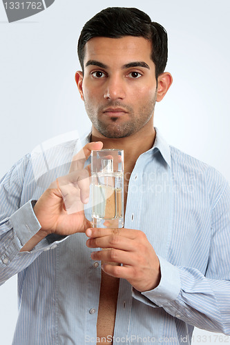 Image of Man holding glass bottle men's cologne
