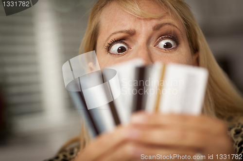 Image of Upset Woman Glaring At Her Many Credit Cards