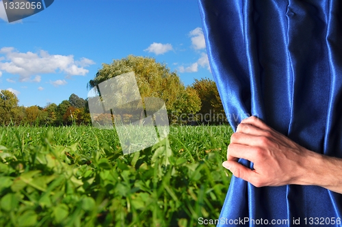 Image of landscape behind blue curtain