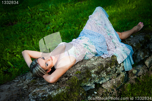 Image of attractive woman lying on stones
