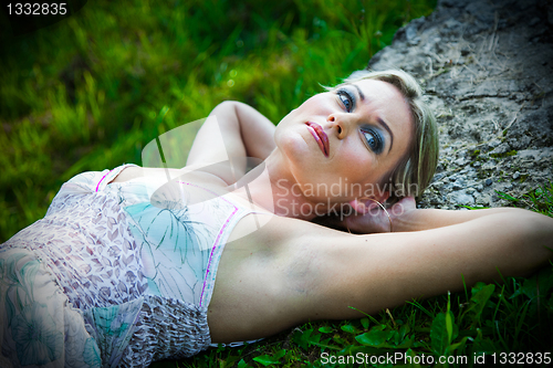 Image of attractive woman lying on stones