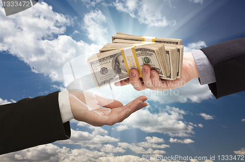 Image of Handing Over Cash with Dramatic Clouds and Sky