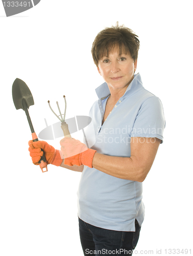 Image of middle age senior woman gardener with spade and cultivator tools