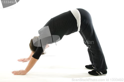 Image of middle age senior woman downward facing dog yoga position