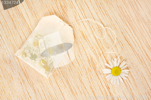 Image of Bag of chamomile tea over wooden background - concept