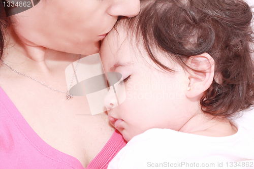 Image of delighted young mother taking care of her adorable baby at home